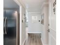 Inviting hallway with modern gray walls and trim, leading to a stainless steel refrigerator and a view of a window at 2965 Pharr Court South Nw # 102, Atlanta, GA 30305