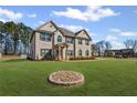 Gorgeous home with lush green lawn and a unique stone-lined flower bed adding charm to the property at 701 Cupcake Ct, Mcdonough, GA 30252