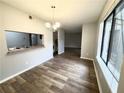 Dining area with wood-look floors, updated chandelier and a view into the kitchen at 925 Seasons Pkwy, Norcross, GA 30093