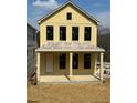 Exterior of new construction yellow house showing front porch with columns at 1919 Repose Dr, Chamblee, GA 30341