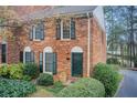 Beautiful brick townhome featuring dark shutters, arched window frames, and professionally landscaped front yard at 213 The South Chace Ne, Sandy Springs, GA 30328