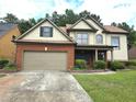 Charming two-story home with a brick and siding exterior, well-manicured lawn, and attached two-car garage at 3070 Ridge Oak Dr, Suwanee, GA 30024