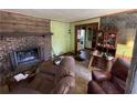 Living room featuring a brick fireplace, hardwood floors, and a vintage cabinet at 3291 Peachtree St, Lithia Springs, GA 30122