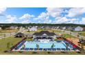 Aerial view of a community pool with ample seating, a splash fountain, and a nearby playground at 169 Aster Avenue, Locust Grove, GA 30248