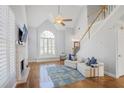 Bright living room with vaulted ceilings, a fireplace, and a view of the staircase at 5085 Hampton Bluff Ct, Roswell, GA 30075