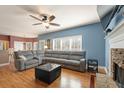 Open-concept living room featuring a stone fireplace and hardwood flooring at 6148 Windflower Dr, Powder Springs, GA 30127