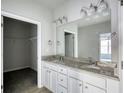 Bright bathroom with granite countertop, double sinks and walk-in closet access at 690 Park Place Way, Social Circle, GA 30025