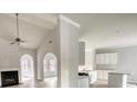 Open living area with fireplace, cathedral ceilings, plenty of windows, and a combined view to the kitchen at 690 Park Place Way, Social Circle, GA 30025