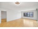Bright living room with beautiful wood floors, white walls, and natural light from a large window at 3481 Lakeside Ne Dr # 807, Atlanta, GA 30326