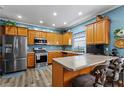 Fully equipped kitchen with breakfast bar seating, stainless appliances, and wood cabinetry at 4695 Ferncrest Pl, Douglasville, GA 30135