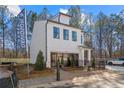 Two-story home with white siding, black trim, and professional signage at 733 Stickley Oak Way, Woodstock, GA 30189