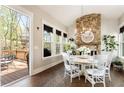 Bright dining room with stone fireplace, views of backyard deck, and stylish chandelier at 3560 Chattahoochee Rd, Cumming, GA 30041