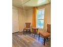 Cozy room featuring two patterned chairs, a small table, a window, and a white door at 2958 Klondike Rd, Lithonia, GA 30038