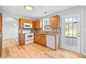 Well-lit kitchen with light wood cabinets, granite countertops, and modern white appliances at 3313 Summit Creek Ln, Loganville, GA 30052