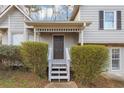 Close-up of the home's front entrance, featuring a covered porch, gray door, and decorative shrubs at 6405 Grafton Dr, Austell, GA 30168
