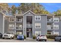 Gray multi-story apartment building complex featuring balconies and well-maintained landscaping at 8303 Santa Fe Pkwy, Atlanta, GA 30350