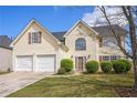 Traditional two-story home with a manicured front lawn, a two-car garage, and a welcoming facade at 1297 Partridge Ln, Riverdale, GA 30296