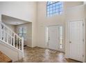 Bright foyer with high ceilings, tile flooring, a staircase, and a large window allowing natural light at 1297 Partridge Ln, Riverdale, GA 30296