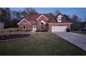 Charming brick home featuring a landscaped front yard and an attached two-car garage at 460 Greystone Ln, Douglasville, GA 30134