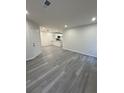 Open-concept living space with gray wood-look flooring and access to the modern kitchen at 596 Windchase Ln, Stone Mountain, GA 30083