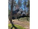 A lovely home featuring a Tudor-style elevation with lush greenery surrounding the property at 285 Old College Way, Atlanta, GA 30328