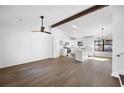 Open-concept living area with hardwood floors, and a beamed ceiling adjoining a modern kitchen at 6730 Alvan Ct, Riverdale, GA 30296