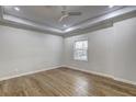 Bright bedroom with hardwood floors, a tray ceiling, and a window overlooking the yard at 810 Commodore Nw Dr, Atlanta, GA 30318