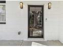 Close-up of the modern glass front door with stylish sconces and a clean, white brick facade at 1350 Elizabeth Sw Ave, Atlanta, GA 30310