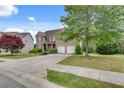 Attractive brick home with a lush front lawn, mature trees, and a convenient two-car garage at 179 Bradshaw Park Dr, Woodstock, GA 30188