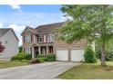Beautiful two-story brick home with an attached two-car garage and a long driveway at 179 Bradshaw Park Dr, Woodstock, GA 30188