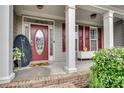 Inviting front porch with brick flooring, columns, and a decorative front door with a glass insert at 179 Bradshaw Park Dr, Woodstock, GA 30188