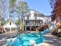 A backyard oasis features a sparkling pool, slide, and a covered patio perfect for outdoor entertaining at 3012 Asheton Ne Pl, Marietta, GA 30068