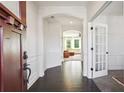 Bright foyer with dark wood floors, decorative moldings, and an arched doorway to the living room at 3774 Thackary Dr, Powder Springs, GA 30127
