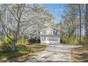 Charming two-story home with a long driveway, set against a backdrop of lush greenery and flowering trees at 656 New Hope Rd, Lawrenceville, GA 30046
