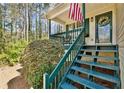 Inviting covered porch with wood stairs leading to the front door, adorned with an American flag and wreath at 656 New Hope Rd, Lawrenceville, GA 30046