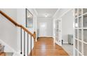 Elegant hallway with hardwood floors, white trim, and a staircase leading to the upper level at 100 Westchester Pass, Peachtree City, GA 30269