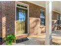Inviting entrance to a brick home featuring a covered porch and a well-maintained landscape at 507 Grove Field Ct, Suwanee, GA 30024