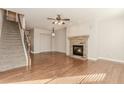 Spacious living room showcases hardwood floors, a stone fireplace, and a staircase to the upper level at 507 Grove Field Ct, Suwanee, GA 30024