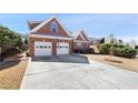 Brick home with a spacious driveway and two-car garage, complemented by green lawn at 1993 Shenley Park Ln, Duluth, GA 30097