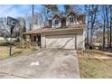 An angle of a charming single-Gathering home with attached garage and basketball hoop in the driveway at 570 Knollwood Dr, Stockbridge, GA 30281