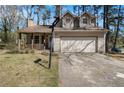 Cozy two-story home with a charming porch, two dormer windows, and attached garage with basketball hoop at 570 Knollwood Dr, Stockbridge, GA 30281