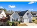 Charming one-story home featuring light gray siding, black shutters, a well-kept lawn, and a convenient attached garage at 165 Birch St, Hiram, GA 30141