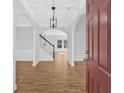 Elegant foyer with hardwood floors, arched doorways, pendant lighting and staircase to the second floor at 9645 Dunhill Way, Cumming, GA 30028