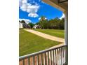 View from the porch of two homes, a long driveway, and lush green grass at 9645 Dunhill Way, Cumming, GA 30028