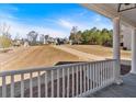 Inviting covered porch with railing offers a scenic view of the landscaped front yard and neighborhood at 9645 Dunhill Way, Cumming, GA 30028