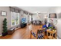 Open-concept living room featuring hardwood floors, large windows, and stylish furniture near the dining room at 2264 Winding Way, Tucker, GA 30084