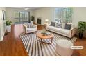 Bright, staged living room featuring hardwood floors, fireplace, and sliding glass door at 3705 Tradewinds Dr, Cumming, GA 30041