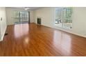 Open living room boasts hardwood floors, fireplace, and natural light at 3705 Tradewinds Dr, Cumming, GA 30041