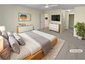 Comfortable staged main bedroom with carpet, dresser, and natural light at 3705 Tradewinds Dr, Cumming, GA 30041