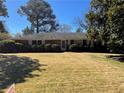 Well-maintained brick home with a neatly kept front lawn and mature trees in a residential neighborhood at 475 Maxwell Rd, Roswell, GA 30075